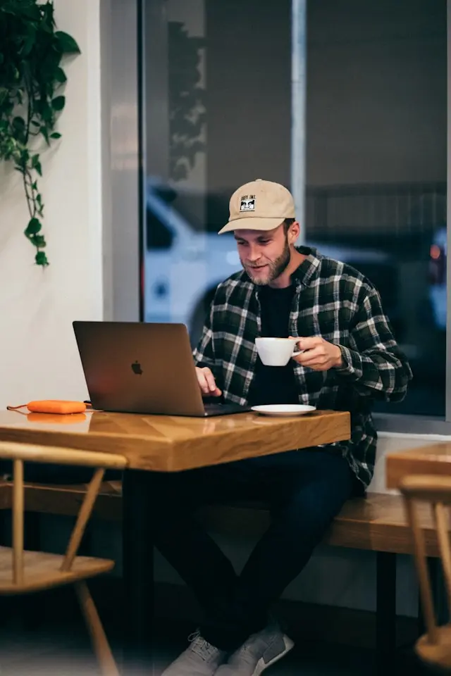 A relaxed person looking for his new feature on a laptop in a coffeeshop
