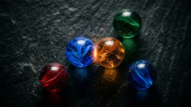 Two coloured marbles touching and glowing, a metaphor for interacting big five traits.